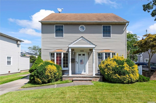 colonial inspired home featuring a front lawn