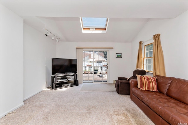 living room with light colored carpet, lofted ceiling with skylight, and track lighting