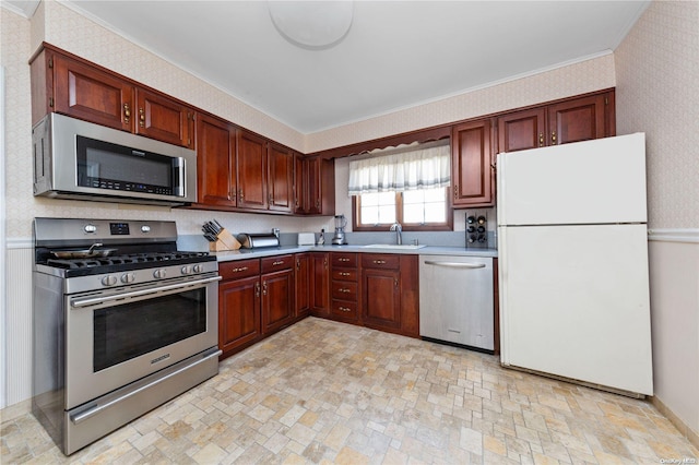 kitchen featuring stainless steel appliances, ornamental molding, and sink