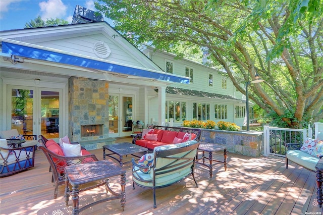 view of patio with french doors, a wooden deck, and an outdoor living space with a fireplace