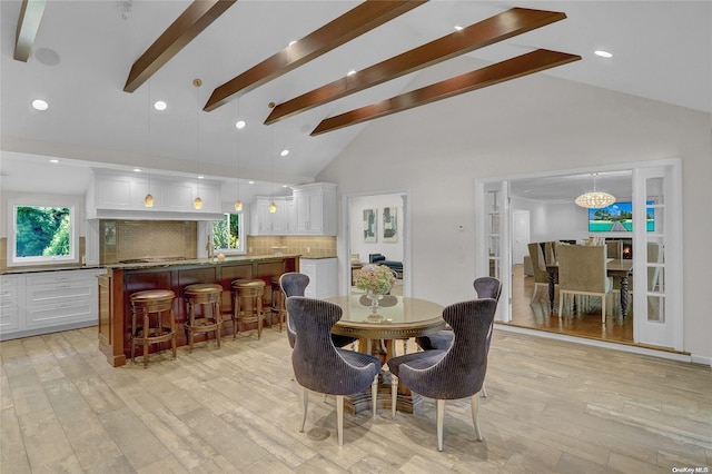 dining area featuring light wood finished floors, an inviting chandelier, high vaulted ceiling, beam ceiling, and recessed lighting