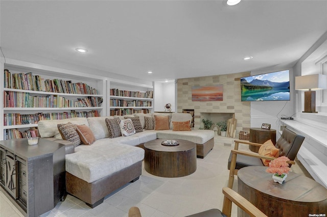 sitting room featuring a tile fireplace, built in features, and recessed lighting