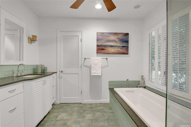 full bathroom featuring tile patterned flooring, ceiling fan, a bath, and vanity