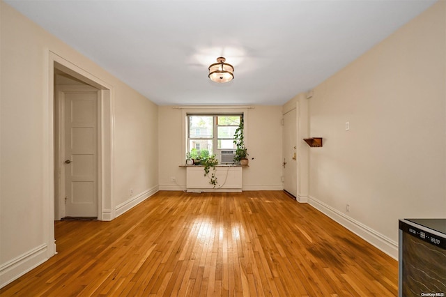 spare room with cooling unit and light wood-type flooring