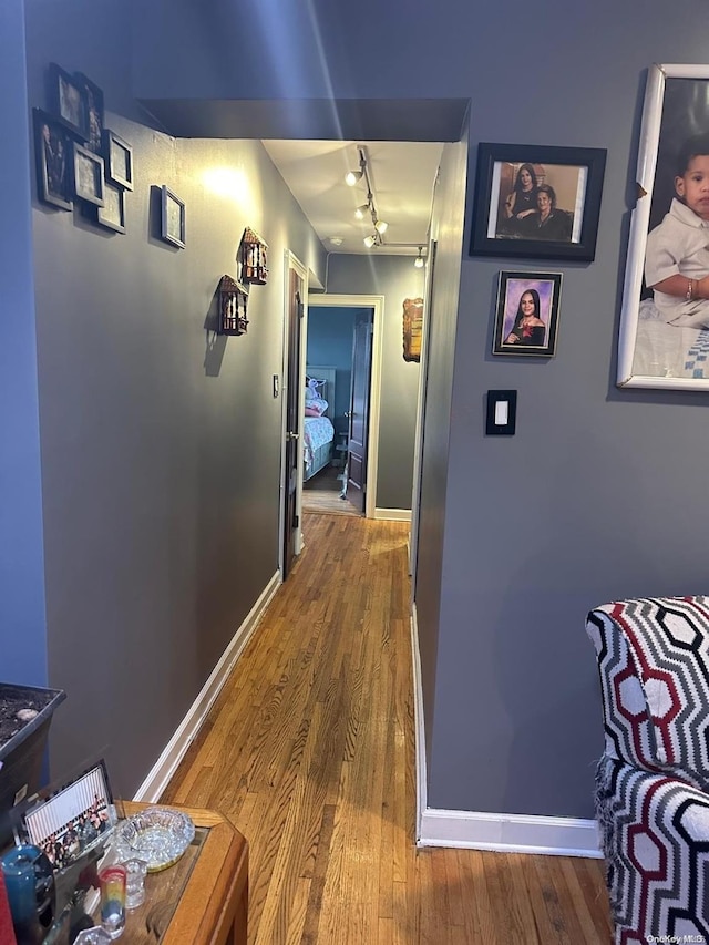 hall featuring hardwood / wood-style flooring and track lighting