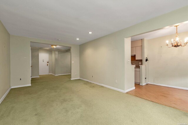 carpeted spare room with a chandelier