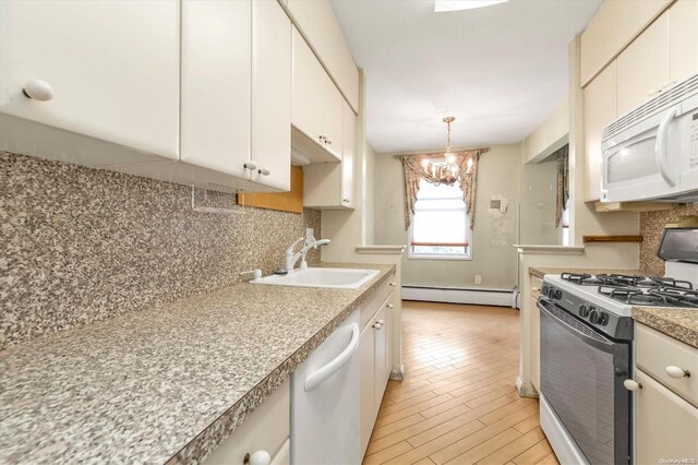 kitchen featuring white appliances, sink, decorative backsplash, baseboard heating, and a chandelier