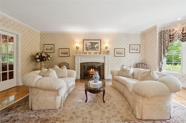 living room with a premium fireplace, ornamental molding, and light wood-type flooring