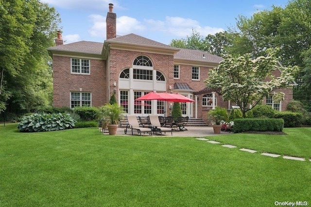 back of house with a lawn and a patio area