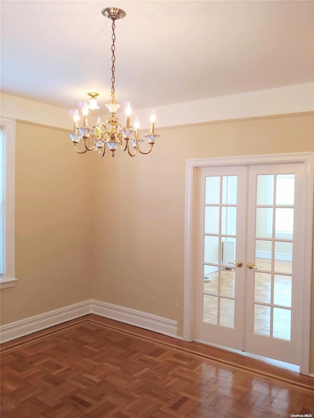 interior space featuring french doors, dark parquet floors, and a notable chandelier