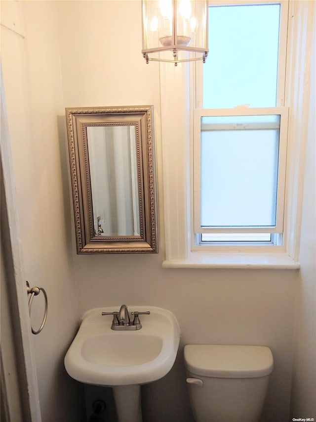 bathroom featuring a chandelier, toilet, and sink