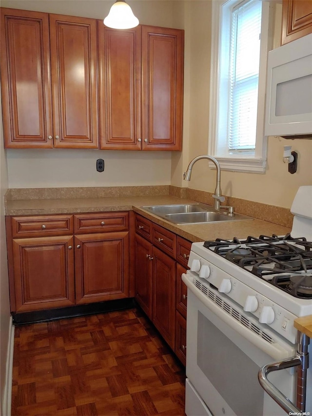 kitchen with white appliances, dark parquet floors, and sink