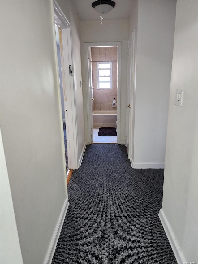 hall featuring dark carpet