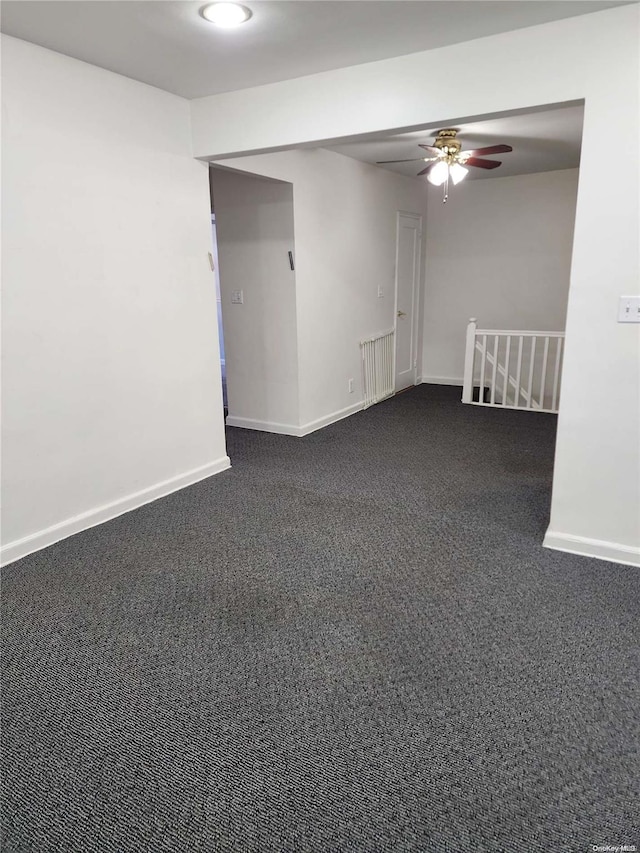 carpeted empty room with radiator and ceiling fan