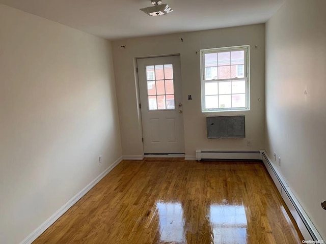 doorway to outside with baseboard heating and light wood-type flooring