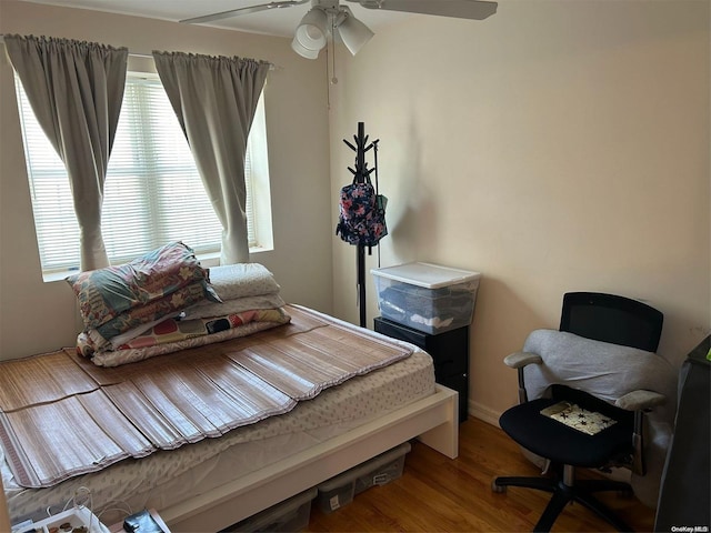 bedroom with wood-type flooring, multiple windows, and ceiling fan