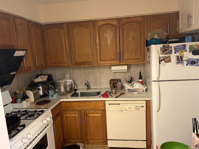 kitchen with backsplash, sink, and white appliances