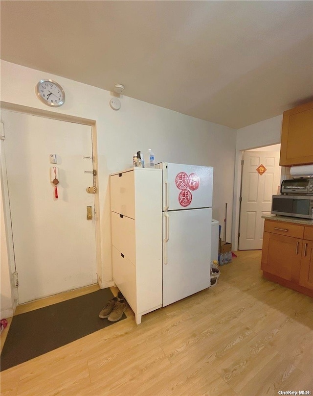 kitchen featuring white refrigerator and light hardwood / wood-style flooring