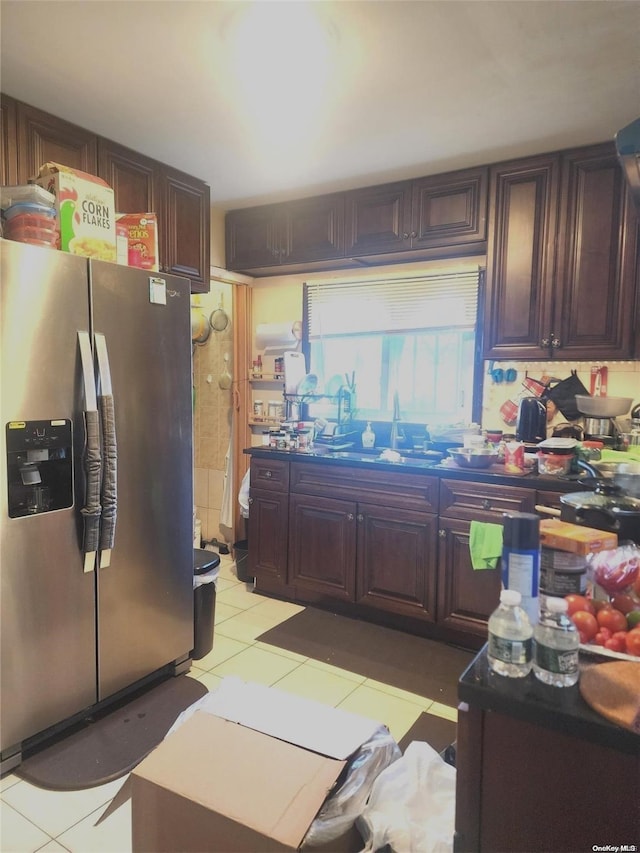 kitchen featuring stainless steel fridge, light tile patterned floors, and sink