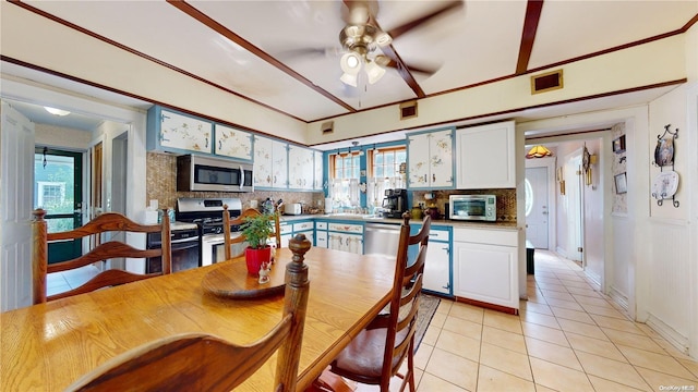 tiled dining space with ceiling fan and a wealth of natural light