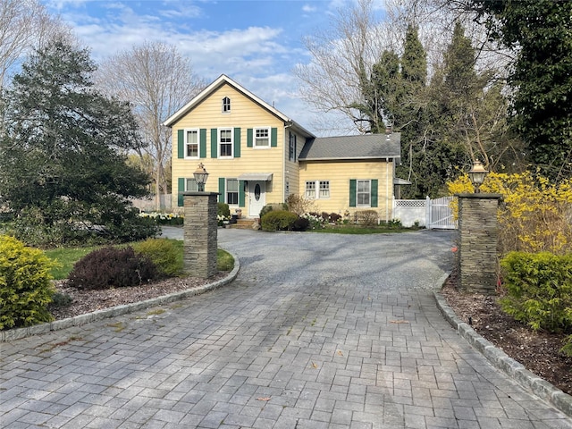 view of front facade featuring fence, a gate, and decorative driveway