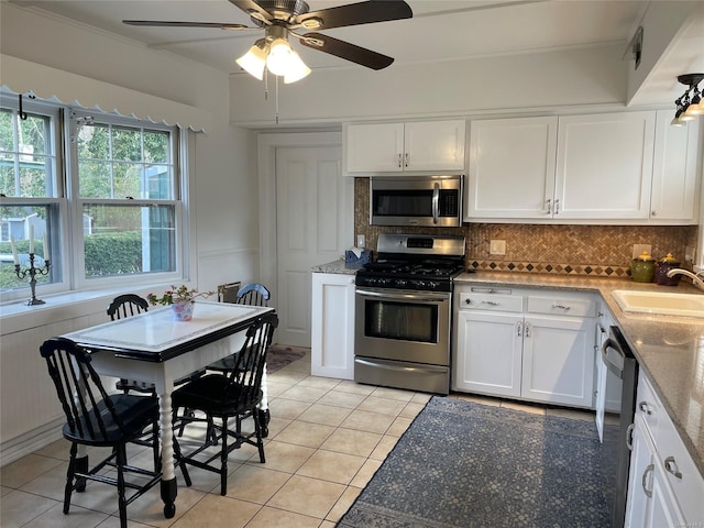 kitchen with a sink, decorative backsplash, appliances with stainless steel finishes, and white cabinetry