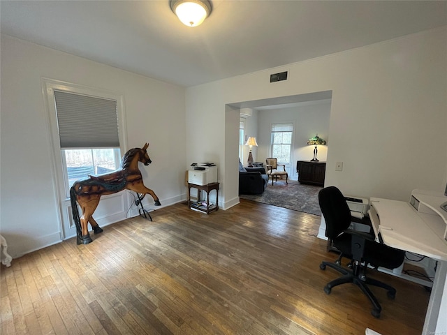 office with baseboards, visible vents, and hardwood / wood-style flooring