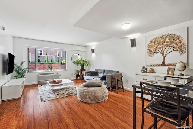 living room featuring hardwood / wood-style floors and a wall unit AC