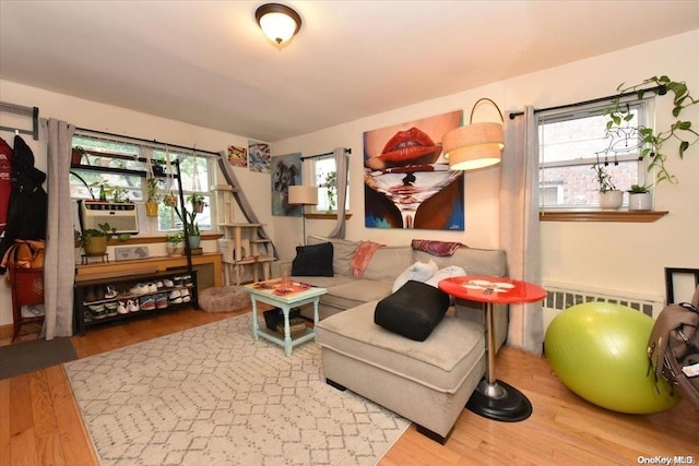 living room with hardwood / wood-style floors, a healthy amount of sunlight, and radiator