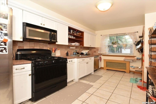 kitchen featuring tasteful backsplash, white cabinets, light tile patterned floors, and appliances with stainless steel finishes