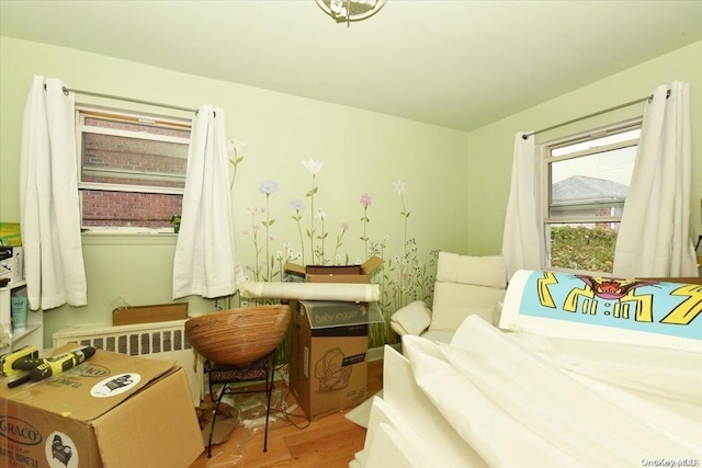 bedroom featuring radiator heating unit and light hardwood / wood-style flooring