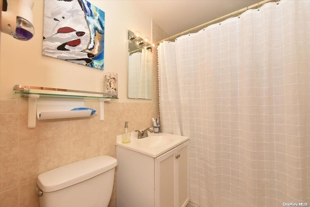 bathroom with vanity, toilet, and tile walls