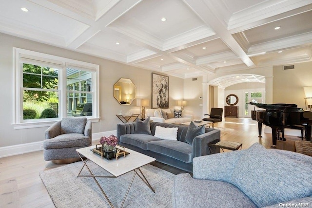 living room featuring beamed ceiling, light wood-type flooring, ornamental molding, and coffered ceiling