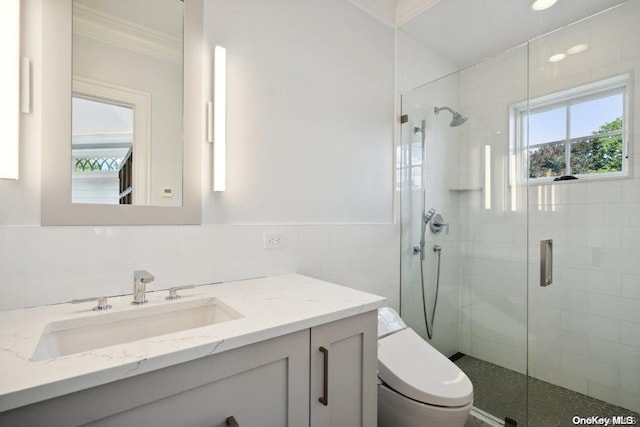 bathroom with vanity, crown molding, tile walls, toilet, and a shower with shower door