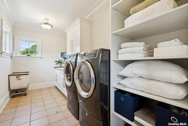 clothes washing area featuring washer and clothes dryer, cabinets, ornamental molding, and light tile patterned floors