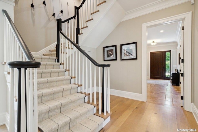 staircase featuring ornamental molding and hardwood / wood-style flooring