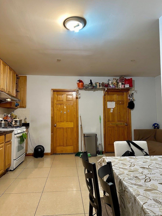 interior space featuring white gas stove and light tile patterned floors