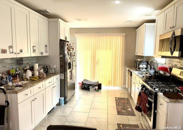 kitchen featuring white cabinets, decorative backsplash, sink, and stainless steel appliances