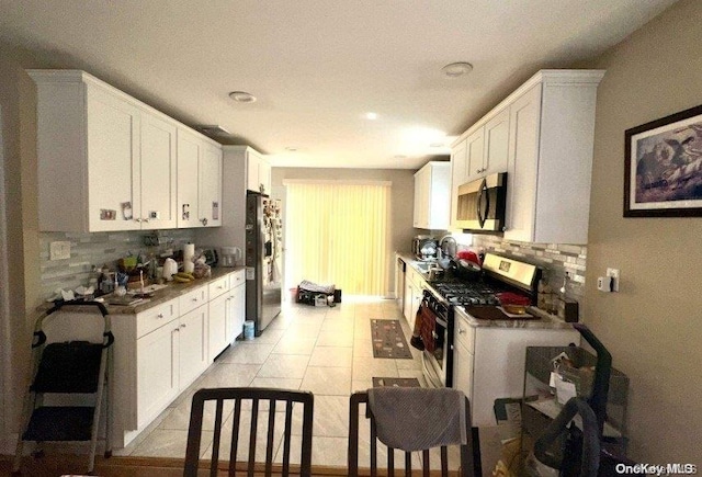 kitchen featuring backsplash, white cabinets, and appliances with stainless steel finishes