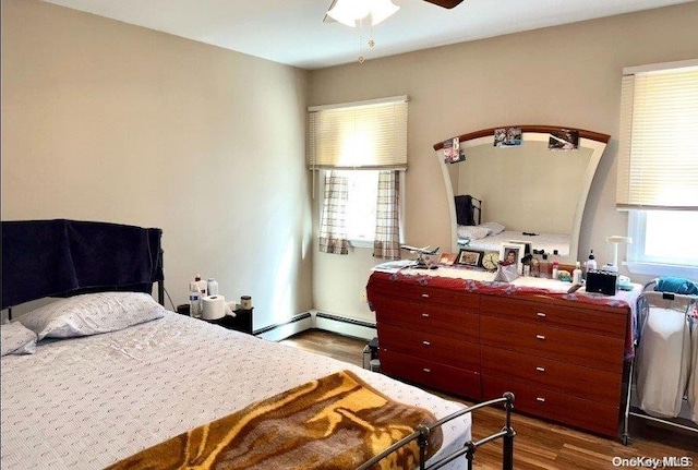 bedroom with hardwood / wood-style floors, ceiling fan, and a baseboard heating unit