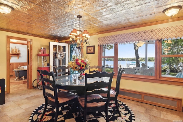 dining room featuring a notable chandelier, a water view, and ornamental molding