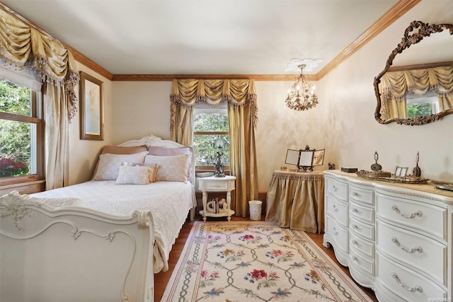 bedroom featuring light hardwood / wood-style floors, crown molding, and a chandelier