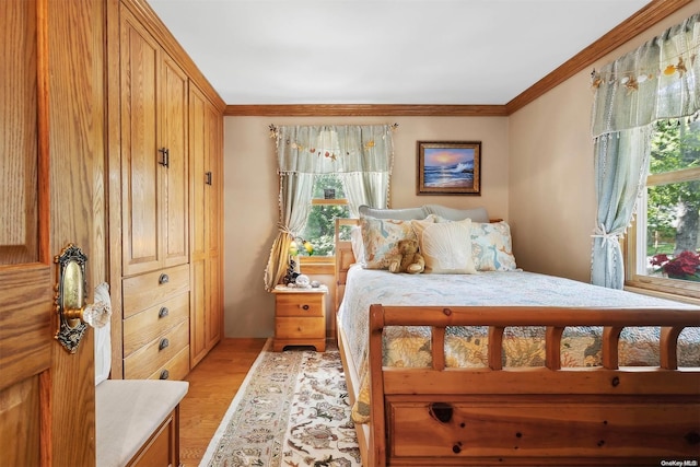 bedroom with light hardwood / wood-style flooring and crown molding