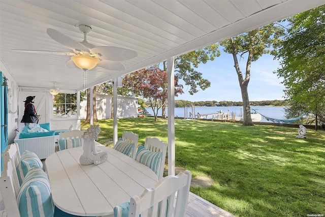 exterior space featuring ceiling fan and a water view