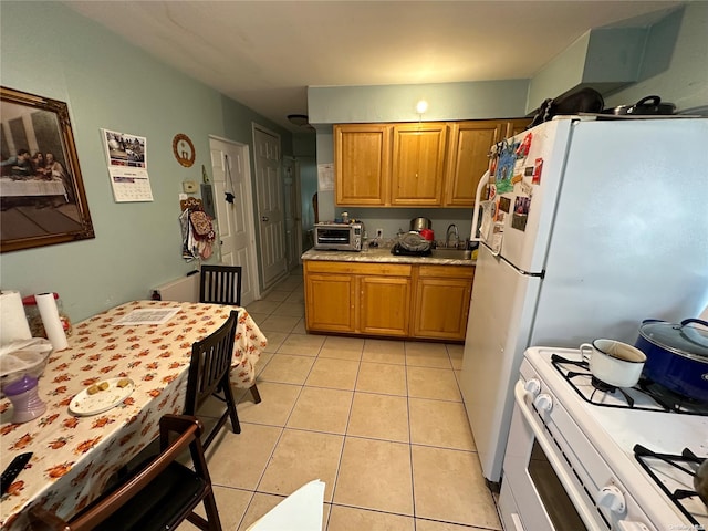 kitchen featuring light tile patterned floors and white appliances