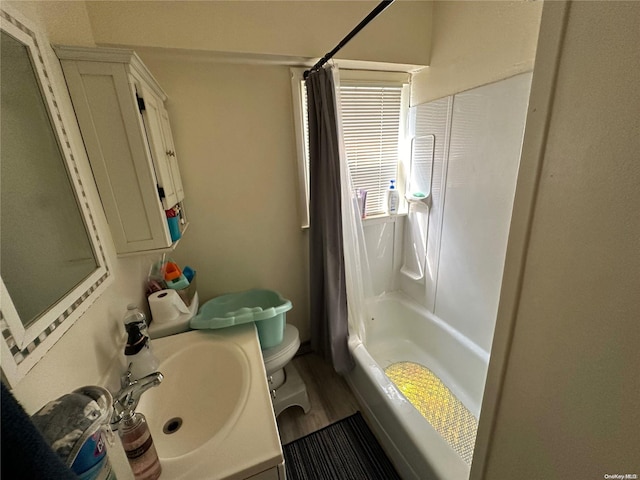 full bathroom with hardwood / wood-style flooring, vanity, shower / bath combination with curtain, and toilet