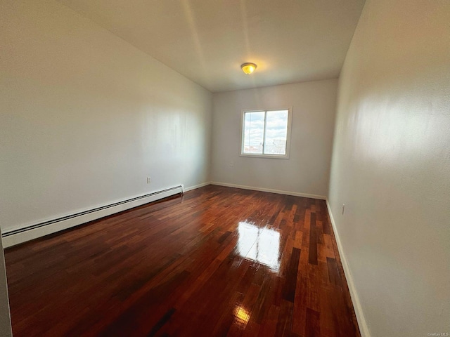 empty room featuring dark hardwood / wood-style flooring and a baseboard radiator