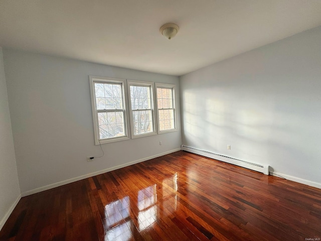 unfurnished room featuring dark wood-type flooring and a baseboard heating unit