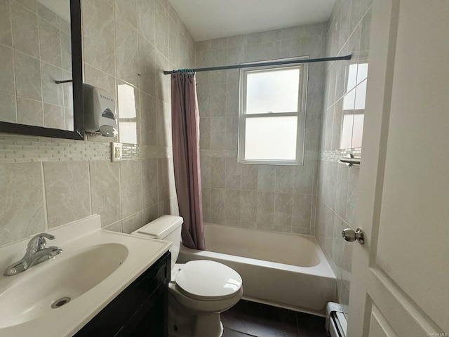 full bathroom featuring a baseboard radiator, toilet, shower / bath combo with shower curtain, vanity, and tile walls