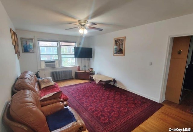 living room featuring hardwood / wood-style floors, radiator, cooling unit, and ceiling fan